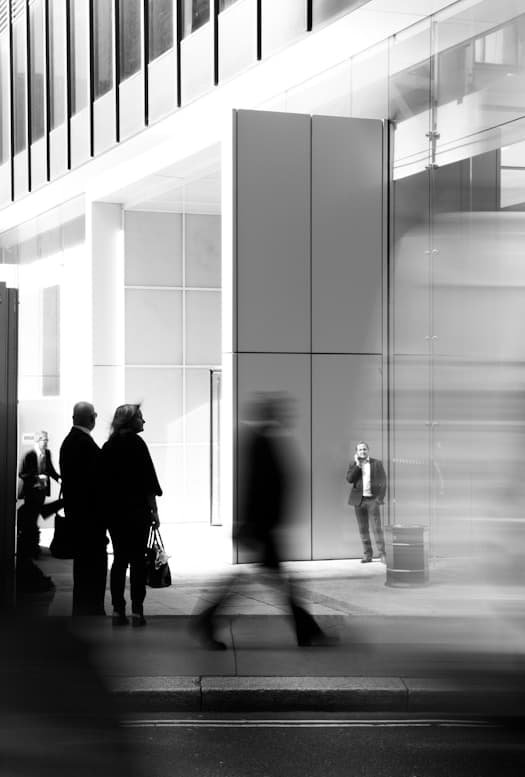 People in a bright glass-walled lobby