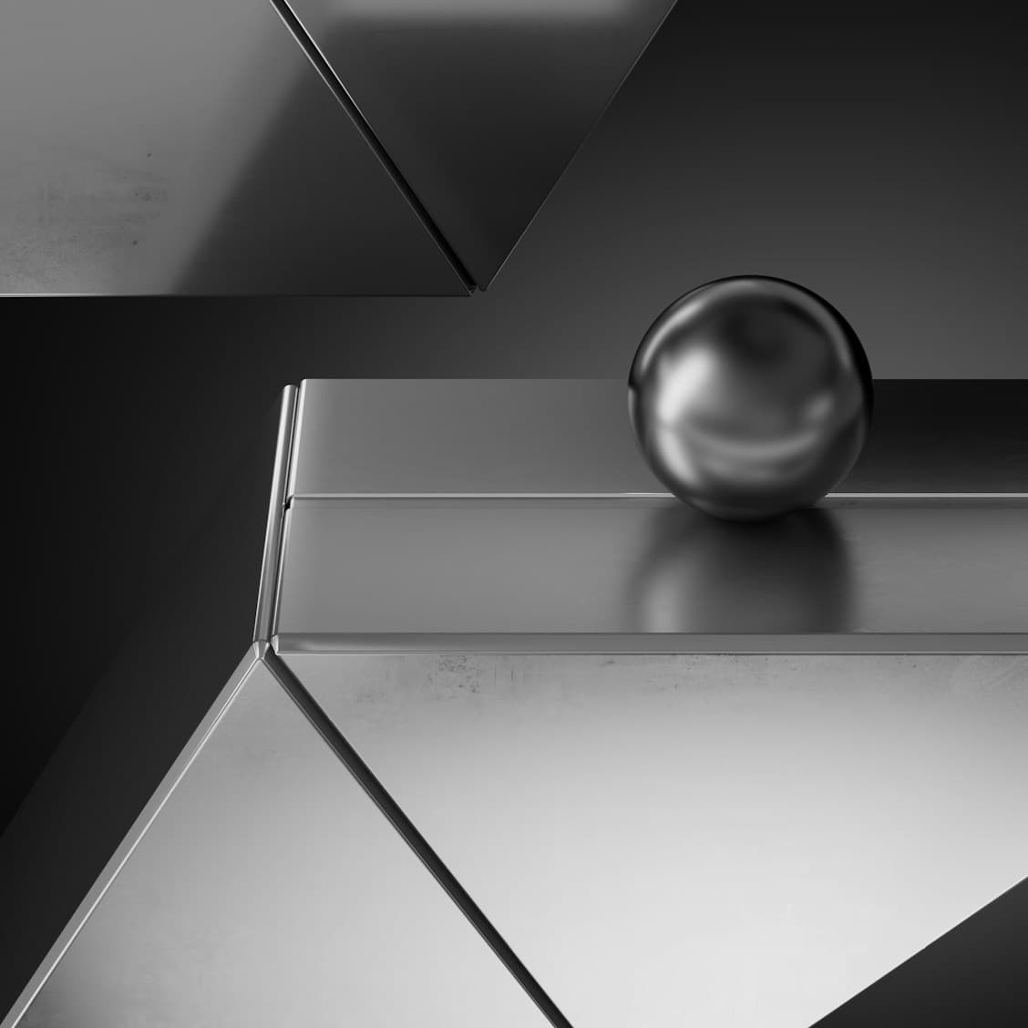 Polished silver sphere resting on brushed metal